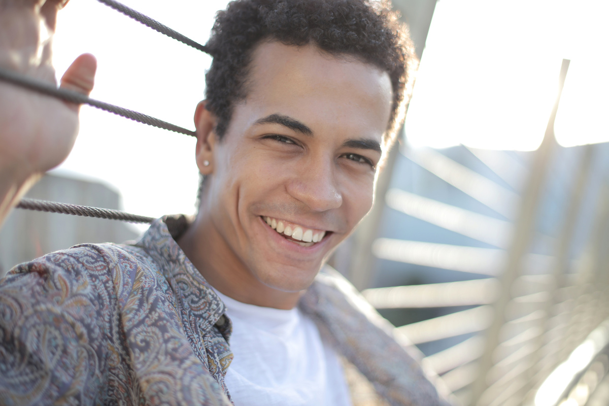 Cheerful ethnic guy toothy smiling at camera